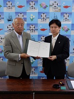調印式での福井市長（左）と当会鈴木会長